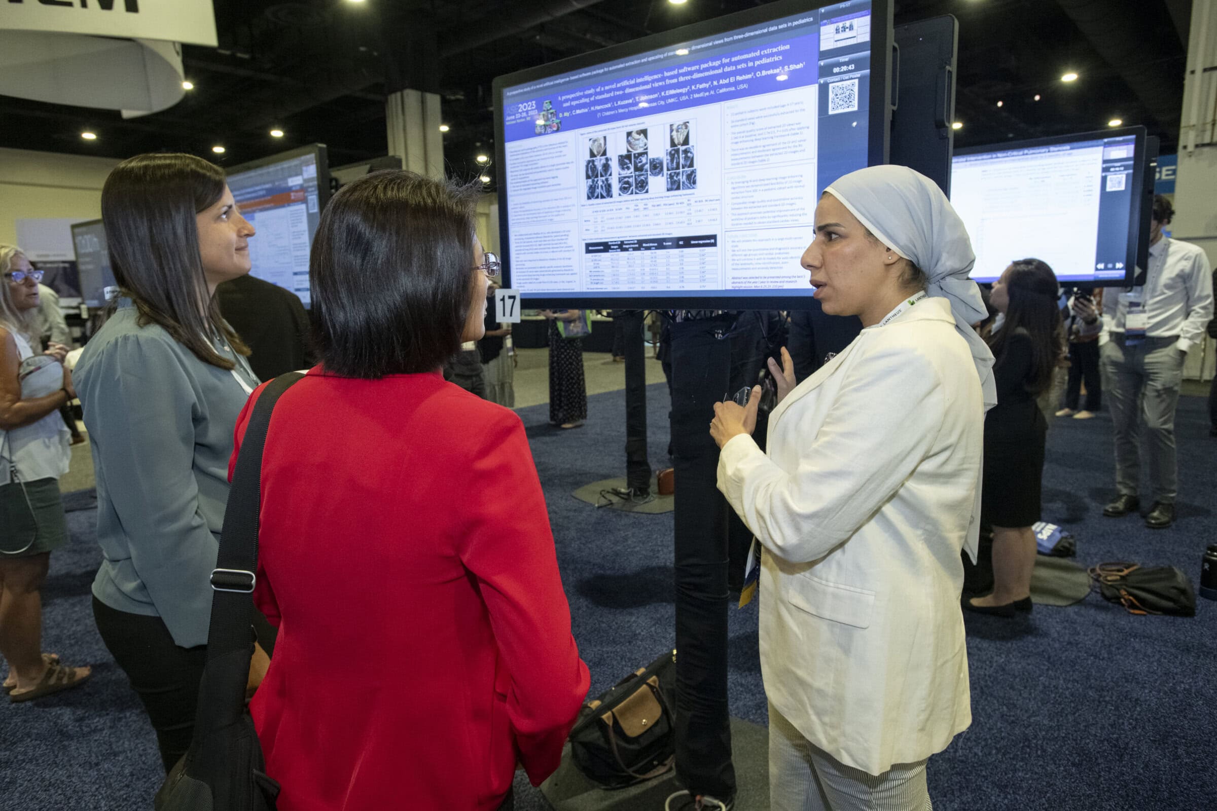 2023 Poster A conference participant presenting her work at a booth