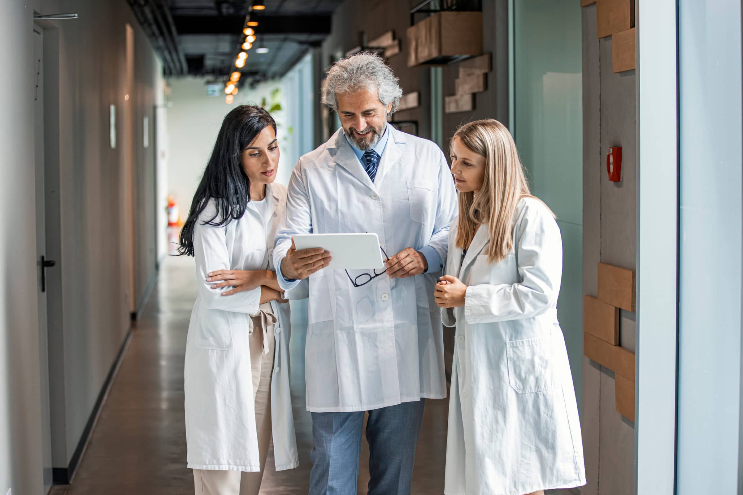 Man,And,Women,Doctor,Having,A,Discussion,In,Hospital,Hallway Man,And,Women,Doctor,Having,A,Discussion,In,Hospital,Hallway